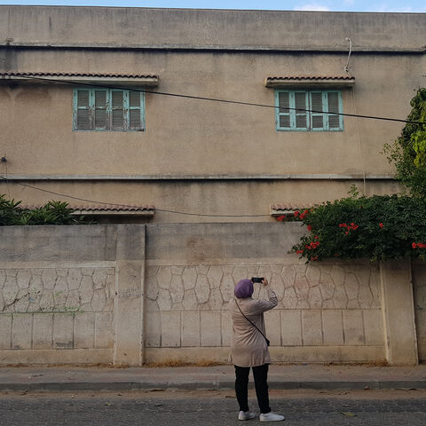 Haya Barzaq takes photographs of a building in Gaza City to track the evolution of architecture in Gaza City, Gaza Strip, June 2022.